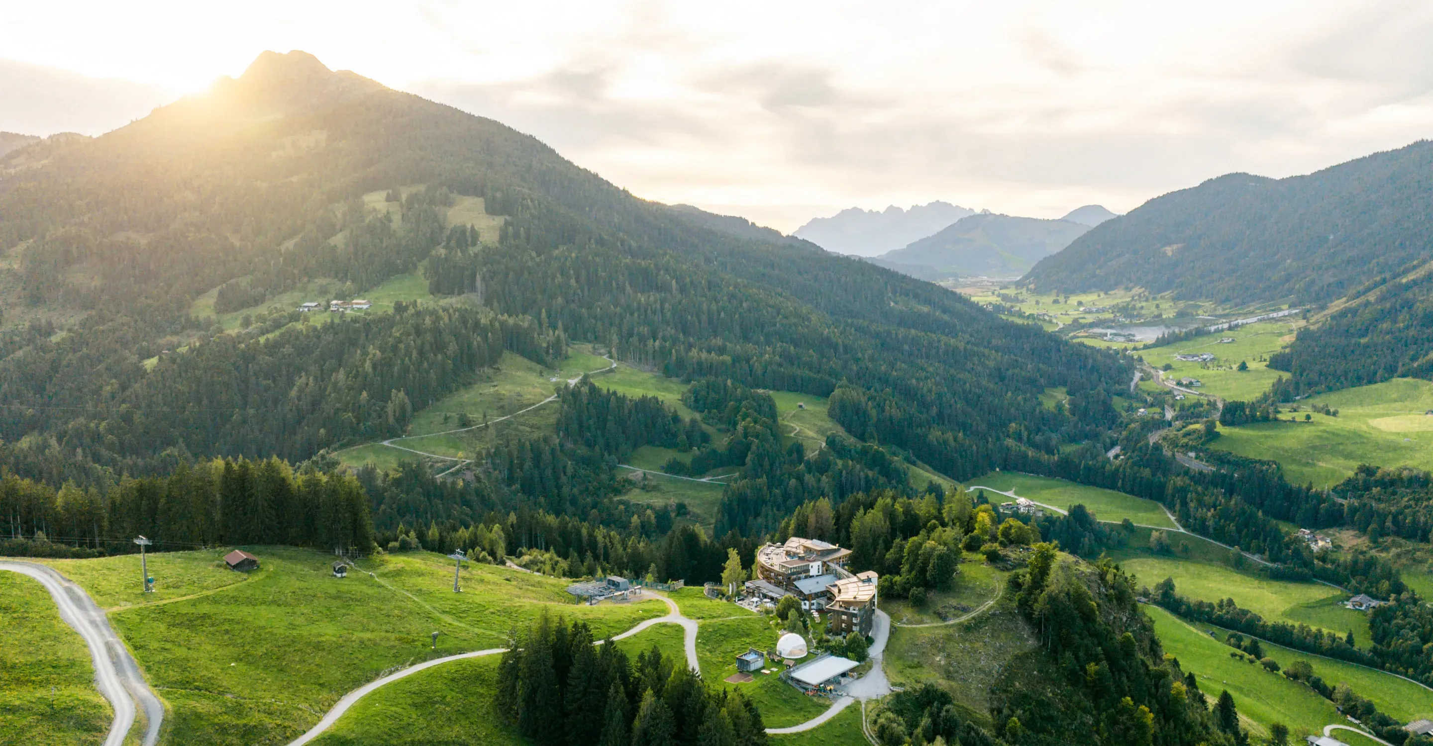 Landschapsopname met bergen en een boerderij
